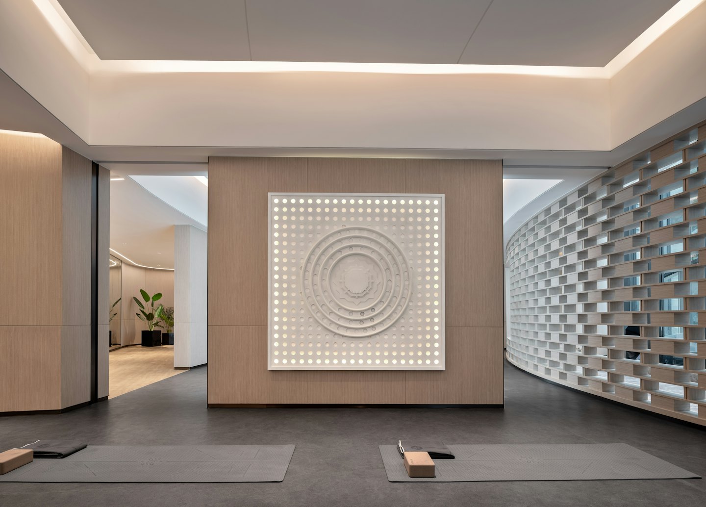 Due tappetini da yoga grigi disposti in uno studio benessere moderno.